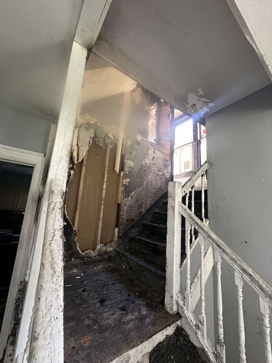 Close-up of fire-damaged stairwell with heavy soot and structural charring