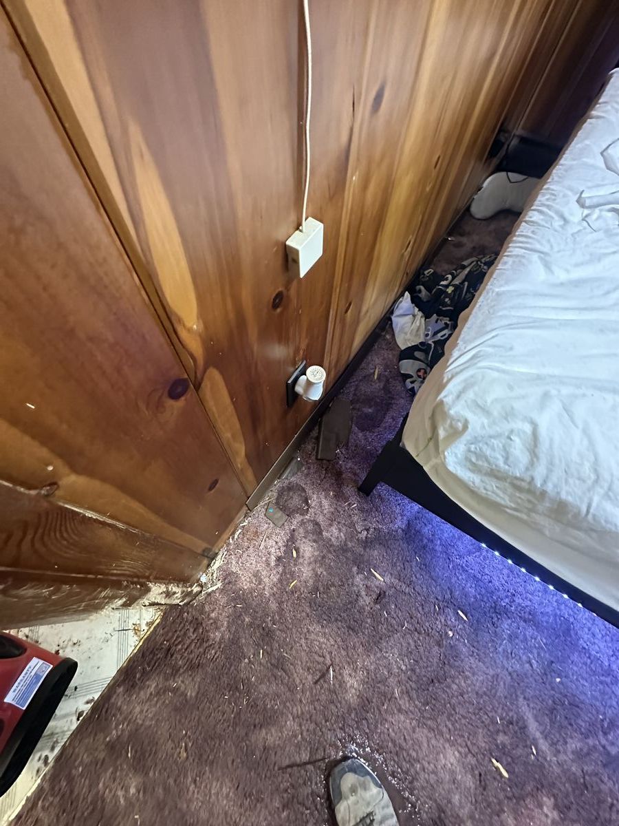 Water-soaked bedroom carpet showing saturation along baseboards